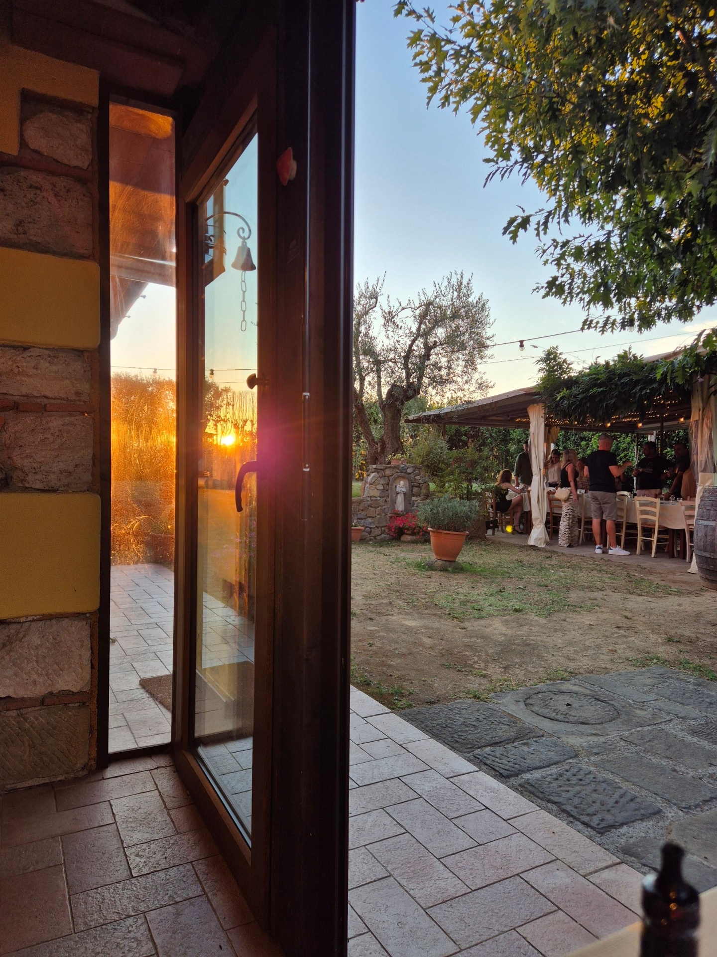Ingresso al tramonto con vista sulla pergola e ospiti