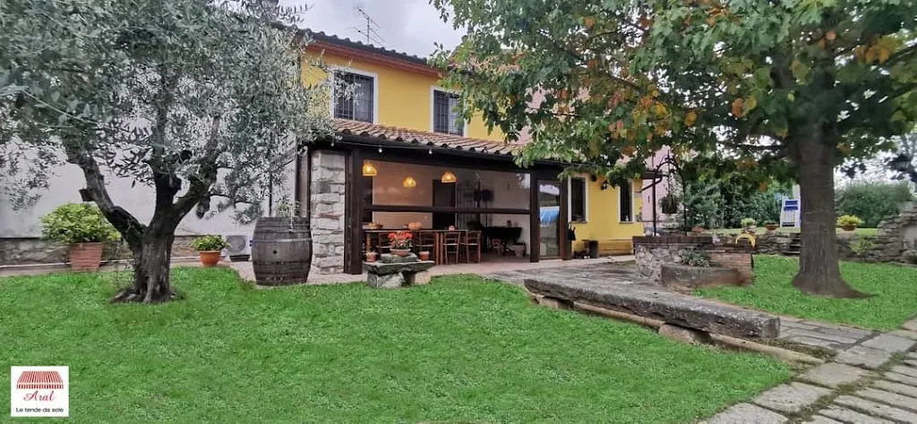 Tavolo apparecchiato all'aperto in agriturismo toscano al tramonto